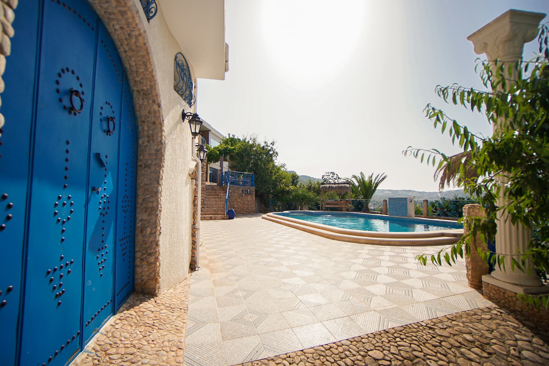 Porte bleue traditionnelle et piscine de la résidence Mille ou une Nuit